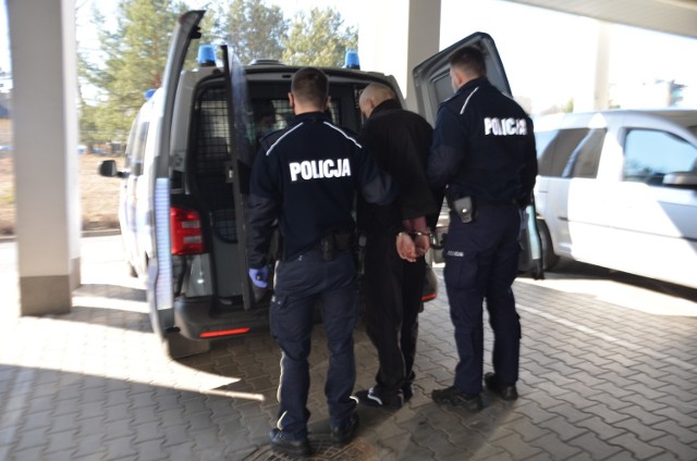 Wyprowadzany przez policjantów w kajdankach 24- letni mieszkaniec Olkusza