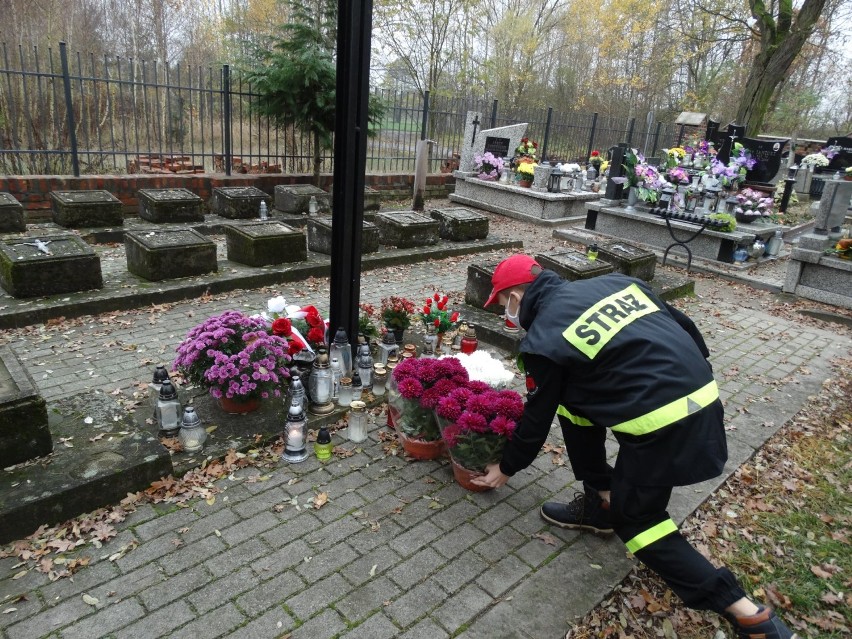 Flaga Polski na Święto Niepodległości przed strażnicą OSP Janiszewice. Z chryzantem