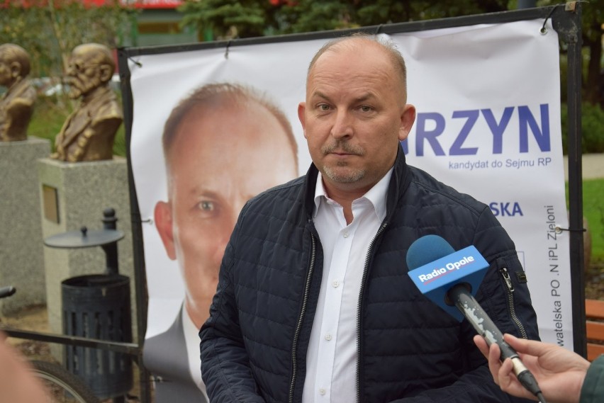 Robert Węgrzyn ciągnie na rowerze przyczepkę ze swoim banerem wyborczym. Chce tak zjeździć całą Opolszczyznę