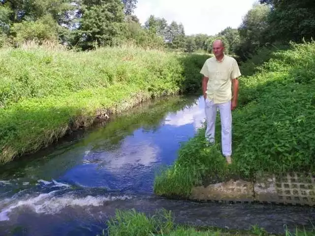 Jarosław Spaczyński w miejscu, gdzie nagrał filmy,  na których widać brunatne ścieki wpływające do rzeki