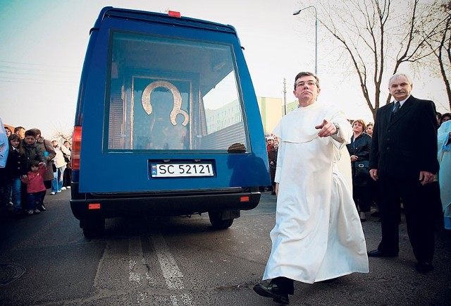 Przez oszklone tylne drzwi furgonetki widać obraz nawiedzający od dwóch tygodni łódzkie kościoły.