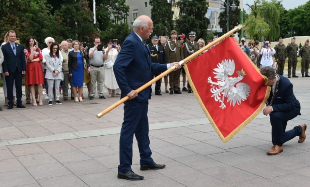 Bogdan Mąder, przewodniczący komitetu fundacyjnego, przekazuje sztandar burmistrzowi Markowi Charzewskiemu.