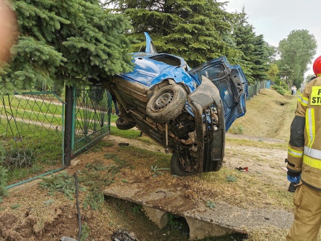Wypadek w Suchej. Fiat odbił się od betonowego mostku i zawisł na ogrodzeniu domu.