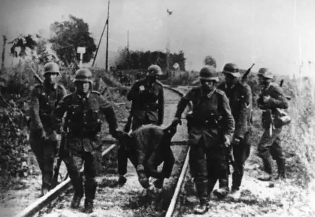 Żołnierze niemieccy wynoszą z pola bitwy na Westerplatte zwłoki, prawdopodobnie polskiego żołnierza