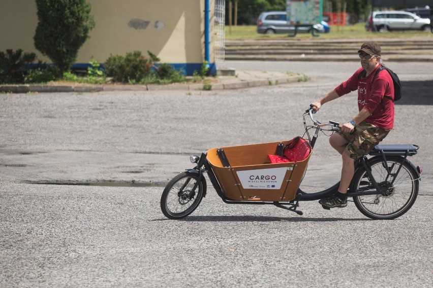 Dwukołowy rower cargo Babboe City-E ma otwartą drewnianą...