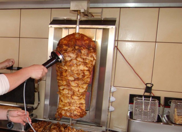 Skrawki opieczonego mięsa plus frytki lub bułka z sosami i dodatkami, czyli kebab