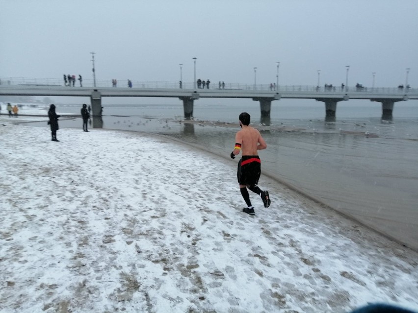 Śnieg, zimny Bałtyk i nagle półnagi biegacz z opaską z w...