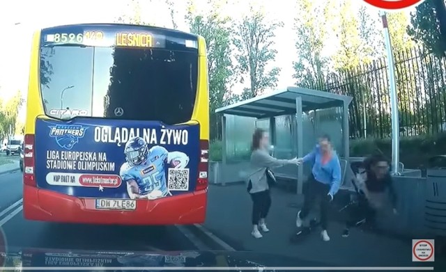 Dwie kobiety wysiadające z autobusu MPK zostają potrącone na przystanku przez kobietę pędzącą elektryczną hulajnogą po wąskim chodniku.