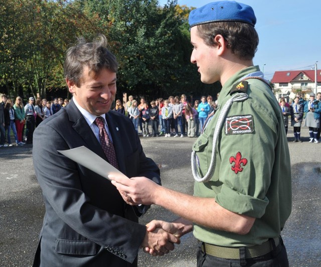 Komendant Hufca ZHP w Dębicy Mateusz Cebula wręcza srebrną honorową odznaką Ruchu Przyjaciół Harcerstwa wiceburmistrzowi Dębicy Mariuszowi Trojanowi