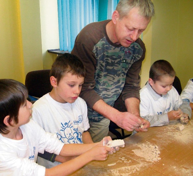 Prof. Adama Bodzioch i mali studenci wydobywają z monolitów szkielety dinozaurów