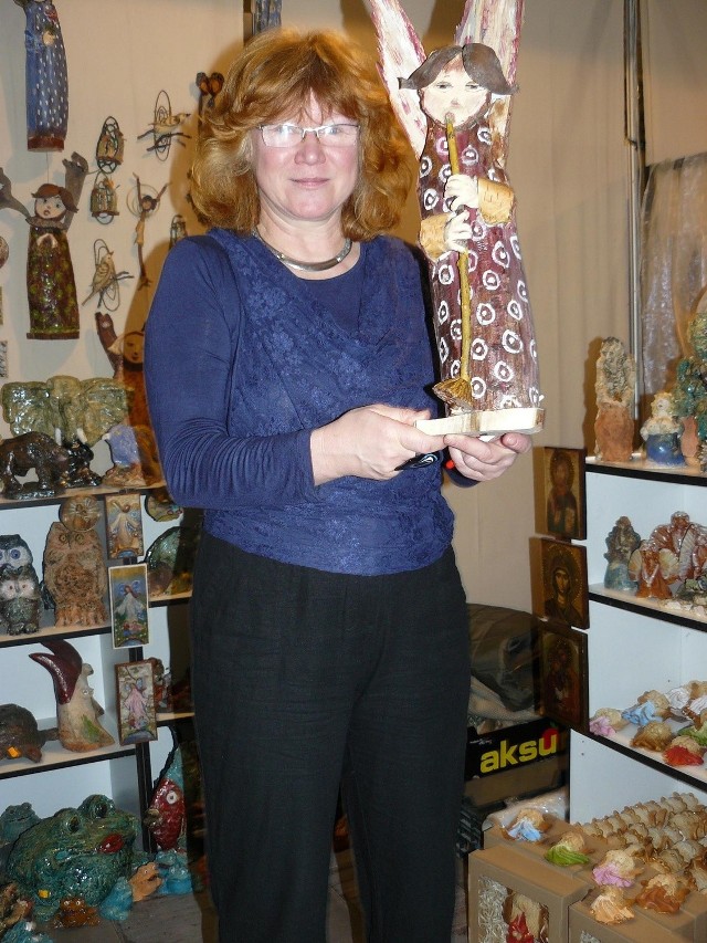 Irena Lech prezentuje jedną z drewnianych figur