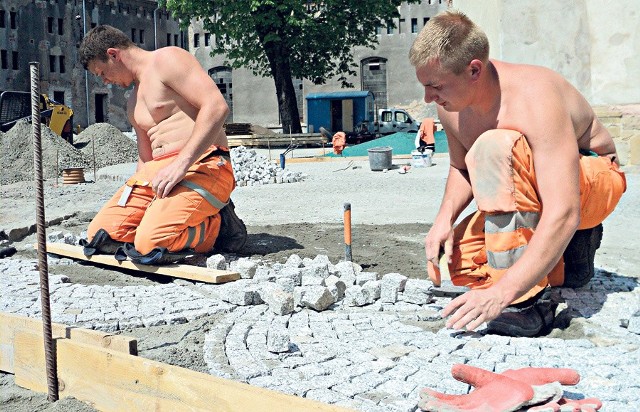 Pracownicy układają bruk na dziedzińcu zamkowym. Remont zakończy się w tym roku