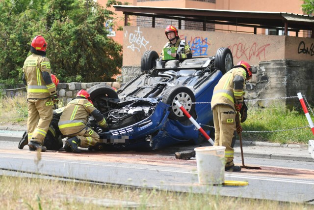 Niebieski volkswagen wypadł z drogi, dachował, ściął słupki i uderzył w betonowy śmietnik. Zatrzymał się na chodniku.