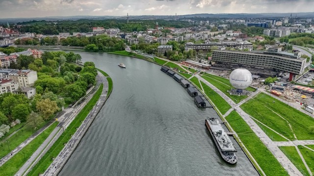 Zielono pod dawnym hotelem Forum w Krakowie. Dawna Plaża Kraków zarosła już trawą, ale trawa zniknęła z rozkopanych przyczółków przyszłej kładki Kazimierz-Ludwinów, która jest w budowie.