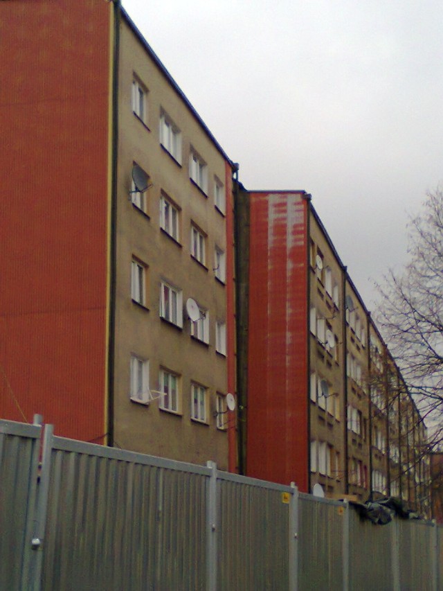 Widok na wyprostowaną klatkę bloku przy ulicy Joliot Curie 1j w dzielnicy Wirek.