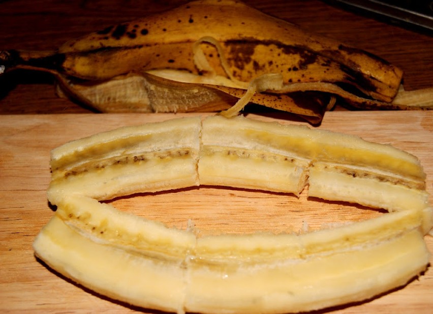 Banan obrać i przeciąć na pół.