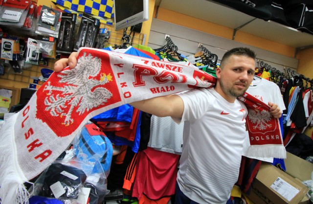 Właściciel salonu piłkarskiego Marcin Wróbel prezentuje gadżety, które najchętniej kupują kibice przed takimi wydarzeniami jak Euro 2016