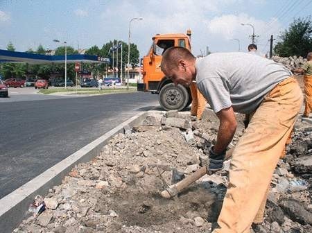 Łukasz Kałuża wybiera starą kostkę brukową w miejscu, gdzie za kilka dni będzie nowy zieleniec.   WOJCIECH TRZCIONKA