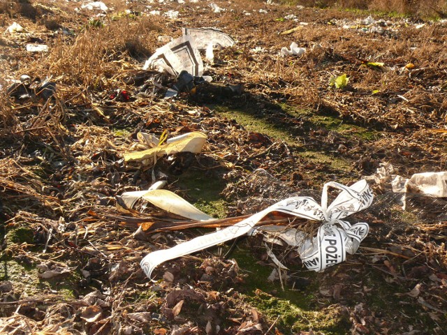 Na jednym z pól w Śliwnie rozsypano śmieci - plastikowe znicze, sztuczne kwiaty, a także wstęgi pogrzebowe.