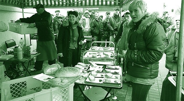 Halina Gromek (z ciemnymi włosami) i Urszula Gronicka (z jasnymi) częstują klientów kiełbaskami i kaszanką z grilla.
