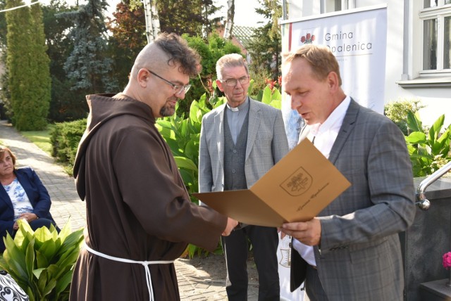 Burmistrz Tomasz Szulc wręczający pamiątkowy adres ojcu Aleksandrowi Horowskiemu.