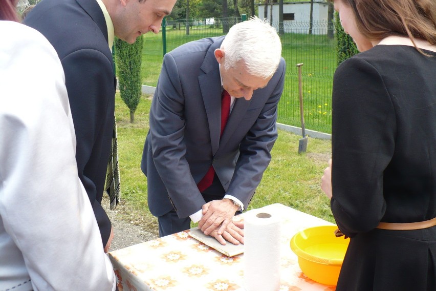 J. Buzek odciska dłoń na pamiątkę wizyty w ZSO.