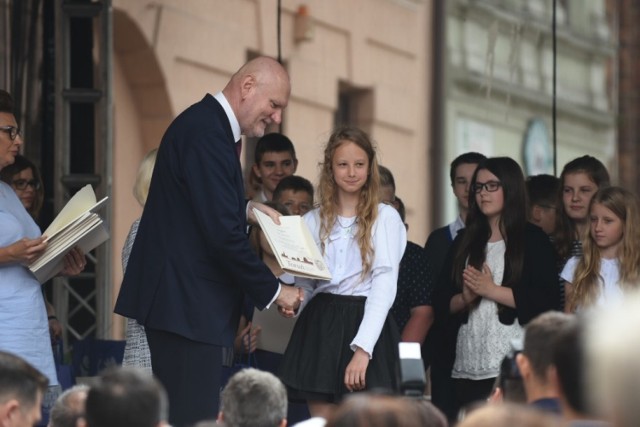 Prezydent Michał Zaleski wręczył 23 czerwca 2017 r. na Rynku Staromiejskim świadectwa toruńskiej klasie, która wyróżniła się w nauce w minionym roku szkolnym. W tym roku świadectwa odebrała klasa VI ze Szkoły Podstawowej nr 27 im. gen. Elżbiety Zawackiej w Toruniu. Aż 22 z 25 uczniów otrzymało świadectwo z wyróżnieniem, a średnia ocen klasy to 5,31.

Zobacz także: Zakończenie roku szkolnego w ZS nr 8 w Toruniu [ZDJĘCIA]
-&nbsp;Gratuluję serdecznie 25 młodym ludziom, którzy potrafili połączyć piękne z pożytecznym, a więc swoje umiejętności i talenty, swoją pasję i miłość do nauki,  z tym pożytecznym, jakim są dobre wyniki w nauczaniu. Spytacie pewnie, dlaczego pożyteczne? Bo budujecie dla siebie fundamenty, fundamenty dla swojej przyszłości. Dlatego, żeby być w życiu tym, kim chcecie zostać. Tylko dobra nauka, skorzystanie z potencjału, jaki przynosi wam szkoła, daje taką szansę – powiedział prezydent Torunia Michał Zaleski.

Poznaliśmy najlepszą klasę w 2016/2017 roku z Torunia [ZDJĘCIA]