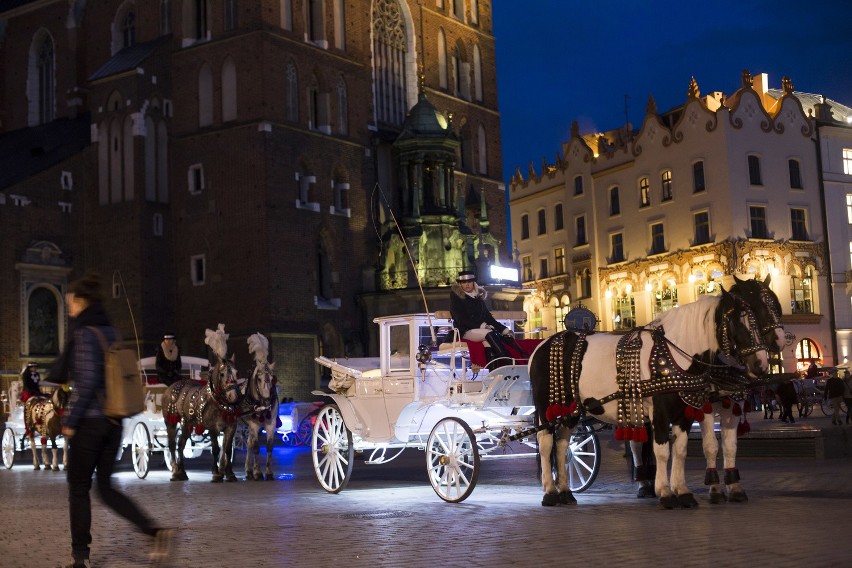 Podświetlone dorożki według dorożkaży i turystów dodają...