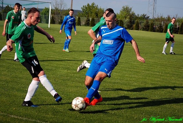 Niebieski strój piłkarz Kujawiaka Kowal Bartosz Śmigiel w zielonym napastnik Dąb Barcin Mateusz Ostrowski