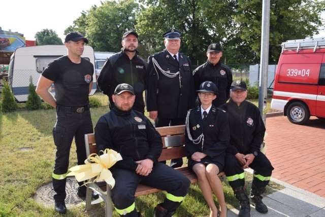 Druhna i druhowie z OSP Pruszcz Gdański na ławeczce obok pruszczańskiej strażnicy