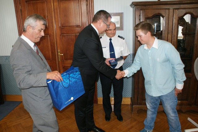 Grzegorz Kozłowski odbiera podziękowania od władz miasta oraz kaliskiej policji