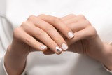 Jesienne paznokcie, które spodobają się minimalistkom i fankom quiet luxury. Pazurki w kolorze kokosowego mleka pięknie wyglądają na dłoni