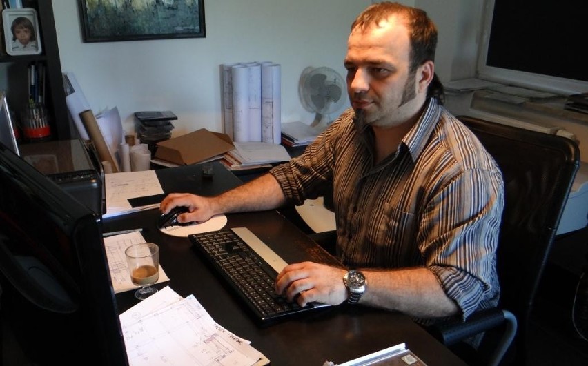 Tomasz Ślęzakiewicz podczas pracy w swoim biurze...