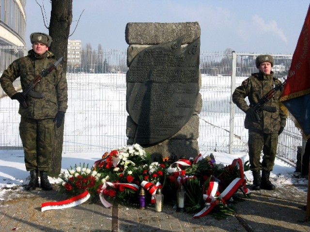 Bukietami białych i czerwonych kwiatów oraz zapalonymi zniczami ...