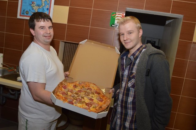 Michał Wietrzycki (z prawej) odbiera pizzę za wytypowanie dokładnego wyniku meczu
