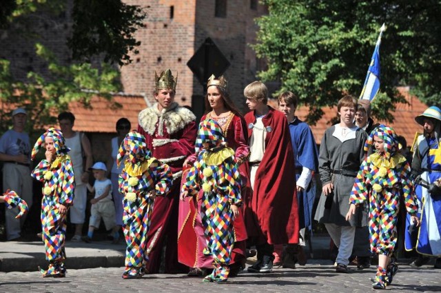 Po mszy, o godzinie 12, z bulwaru nad Nogatem, spod budynku Szkoły Łacińskiej, ruszy tradycyjny średniowieczny korowód, który zmierzać będzie do centrum miasta, na plac Kazimierza Jagiellończyka. W korowodzie wezmą udział uczestnicy festiwalu, uczniowie i nauczyciele malborskich szkół i przedszkoli, grupy rycerskie, przedstawiciele miast partnerskich, samorządu i wielu znamienitych gości, oraz - mamy nadzieję - wszyscy chętni mieszkańcy naszego miasta. Serdecznie zapraszamy wszystkich, którzy chcą razem z nami świętować jubileusz miasta do przyłączenia się do korowodu. Pochód urozmaicą scenki rodzajowe, przygotowane przez uczniów i nauczycieli Szkoły Podstawowej nr 3, Gimnazjum nr 3 i Zespołu Szkół Ponadgimnazjalnych nr 2. 

Na centralnym placu miasta, po uroczystym powitaniu wszystkich gości i samego Króla Kazimierza Jagiellończyka, będzie można obejrzeć plenerowy średniowieczność-jarmarczny spektakl "Księga Błazna - moralitet plebejski w wykonaniu Teatru Rozrywki TRÓJKĄT. 

Od 13.00 na placu działać też będzie jarmark średniowieczny, a na nim wyroby miejscowych rzemieślników, stoiska miast partnerskim ze smacznym poczęstunkiem oraz stargany przygotowane przez szkoły - Szkołę Podstawową nr 9, Gimnazjum nr 3 i Zespół szkół Ponadgimnazjalnych nr 2. Jarmark średniowieczny otwarty będzie dla odwiedzających do 18.00.