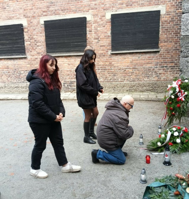 Prezes oświęcimskiego oddziału Towarzystwa Opieki nad Oświęcimiem Pamięć o Auschwitz Marek Księżarczyk wraz z młodzieżą w przeddzień 79. rocznicy wyzwolenia obozu zapalił znicze przed Ścianą Śmierci