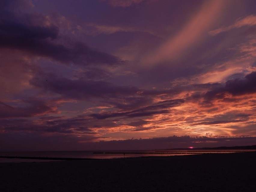 Słońce wschodzące nad ustecką plażą w czasie burzy