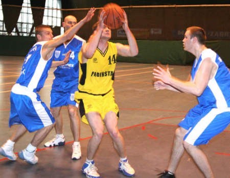 Zawodnik MKKS Zabrze, Grzegorz Zadęcki (drugi z prawej), chce wykonać rzut, ale przeszkadzają mu koszykarze Pogoni Prudnik.