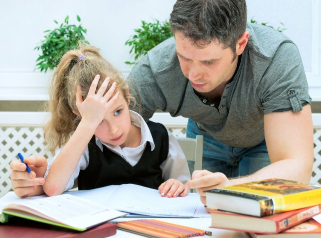 Ojciec odrabia zadania domowe z córką.
