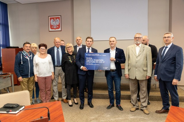 Poseł PiS Bartosz Kownacki w obecności radnych wręczył burmistrzowi Waldemarowi Stupałkowskiemu symboliczny czek