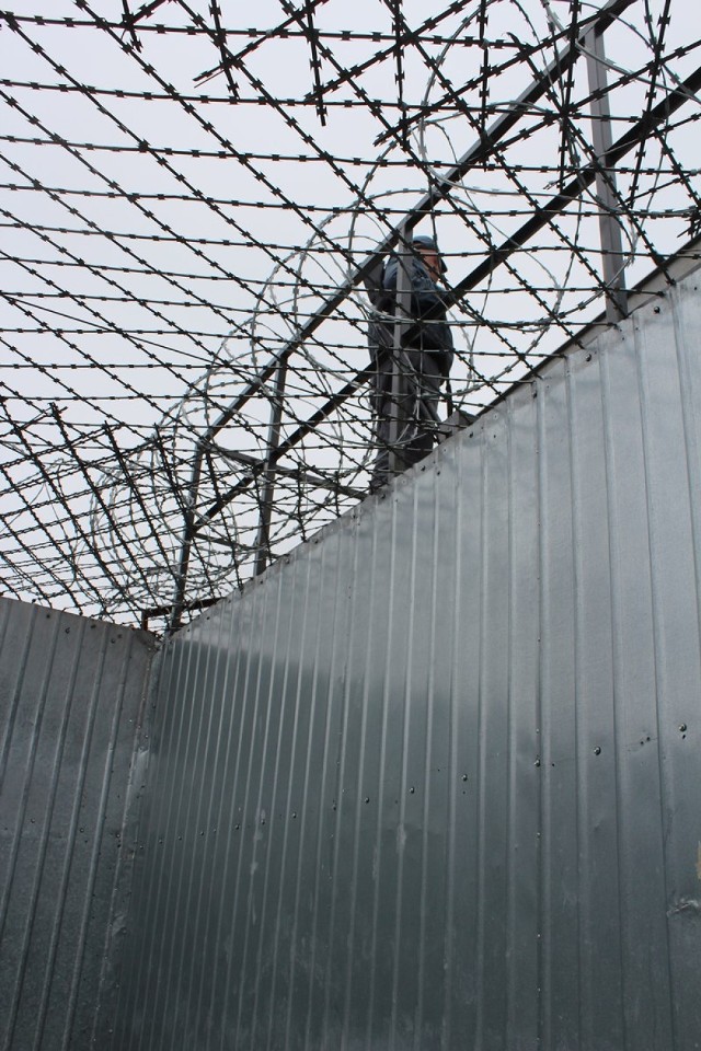 Pole spacerowe. 
Nad bezpieczeństwem więźniów, którzy są na spacerniaku cały czas czuwają strażnicy więzienni. Mundurowi zawsze mają przy sobie broń gładkolufową.