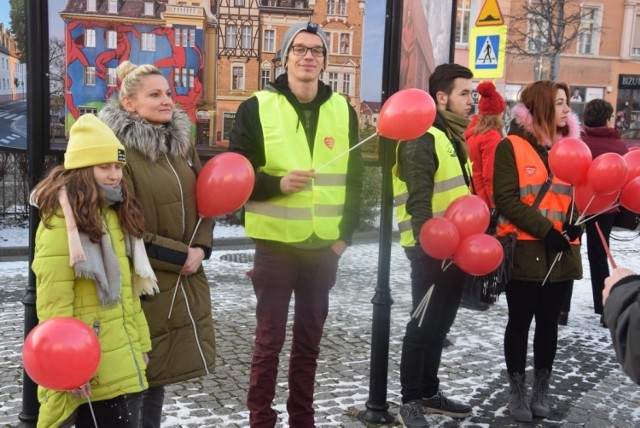  Dzień po ogłoszeniu przez Jerzego Owsiaka decyzji, że jednak wraca na fotel prezesa fundacji Wielkiej Orkiestry Świątecznej Pomocy, 10-osobowe stowarzyszenie „Nowosolska Paczka” zorganizowało z tej okazji w centrum miasta happening, popierający tę decyzję.



W sobotę, 19 stycznia, pojawiła się informacja, że Jerzy Owsiak zostaje z nami i postanowiliśmy się tu spotkać z mieszkańcami miasta – poinformował nas szef stowarzyszenia, Marcin Mańkowski. Początkowo była to mała grupka ludzi, ale z czasem, mimo przenikliwego chłodu, zaczęło się zbierać coraz więcej mieszkańców, którym nieobca jest idea J. Owsiaka. Wszyscy ustawili się koło muralu, robiąc figurę serduszka, co uwiecznił krążący nad nimi dron. Z masłej grupki zrobił się niemały tłumek ludzi...

