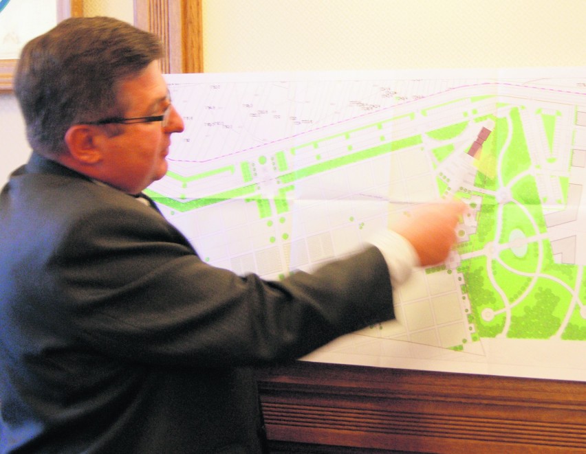 Burmistrz Marek Fryźlewicz pokazuje plan nowego cmentarza,...