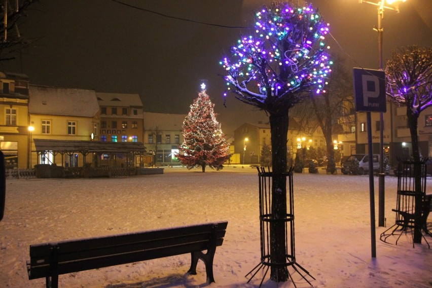 Światełka na ulicach miasta rozjaśniają noc i połyskują w śniegu