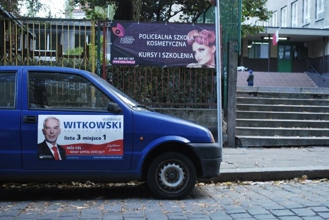 Samochód z plakatami jednego z kandydatów stał przed lokalem wyborczym.