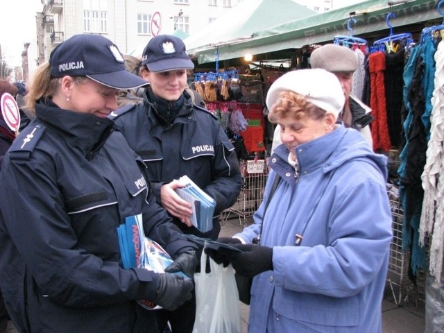 Rynek Jeżycki. Pani Alicja bierze od policjantów ulotki o tym, jak uchronić się przed kieszonkowcami.