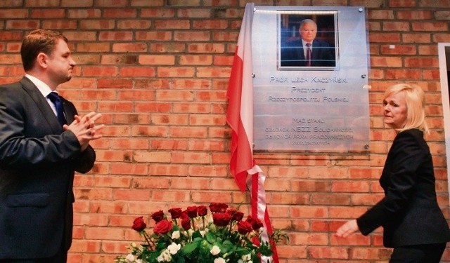 Piotr Duda i Bożena Borys-Szopa przy tablicy upamiętniającej Lecha Kaczyńskiego