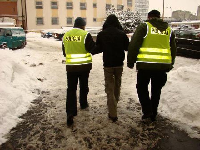 Policjanci prowadzą 36-latka, który napadł na siedem banków rabując w sumie 70 tysięcy zlotych