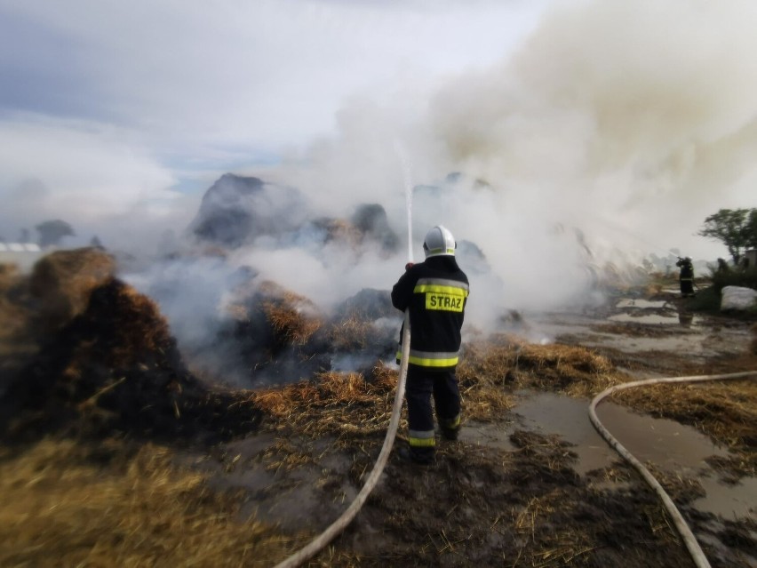 Strażacy dogaszają pożar po uderzeniu pioruna w stóg siana w...